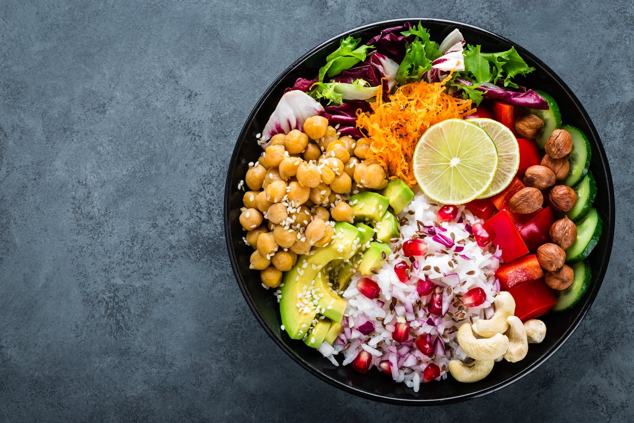 Eine Schüssel mit Kichererbsen, Avocado, Reis, Paprika und Nüssen